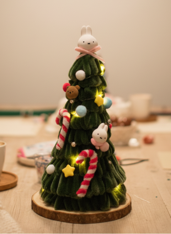 Decorative Christmas tree with lights and small animal figurines on a wooden surface.